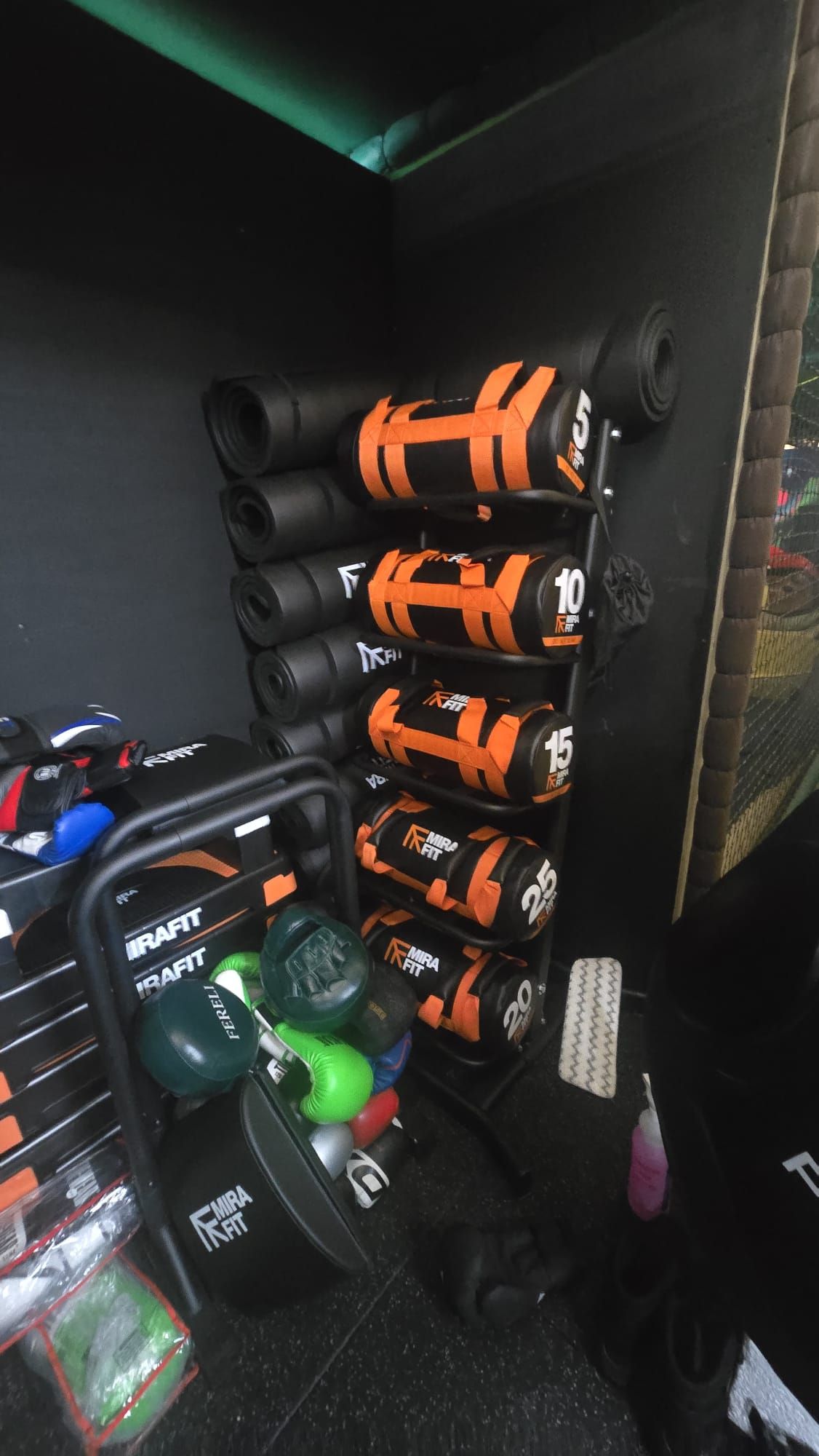 Rack of orange and black MIRAFIT weighted power bags from 5kg to 25kg